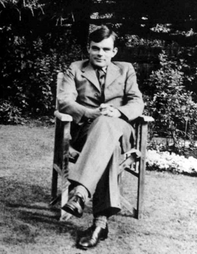 Alan Turing assis dans une chaise de jardin vers 1938.